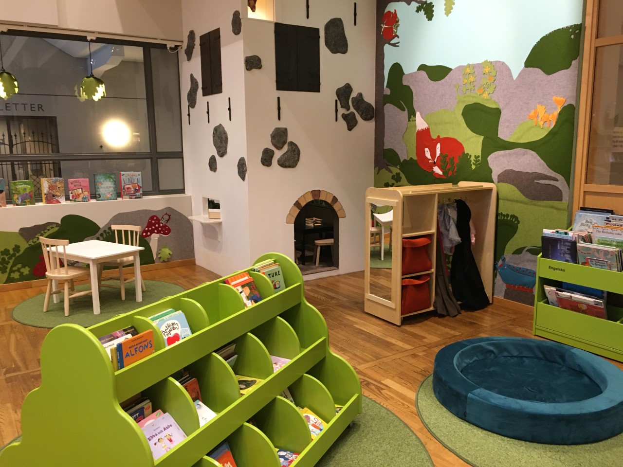 Barnavdelning på ett bibliotek som är uppbyggd som ett skogslandskap